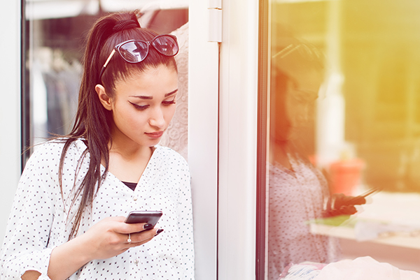 Young woman looking down at smartphone