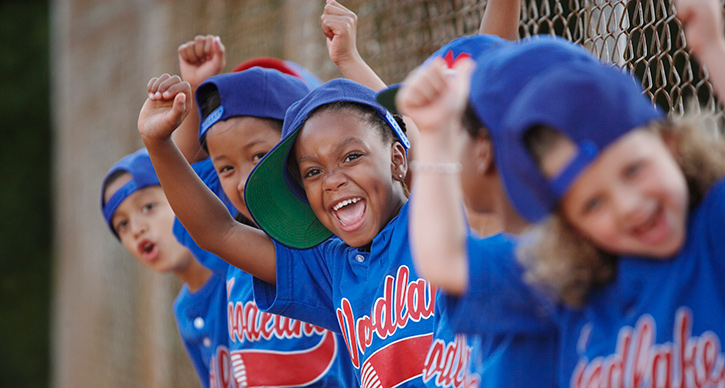 children in baseball uniforms cheering