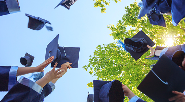 college graduates throwing caps