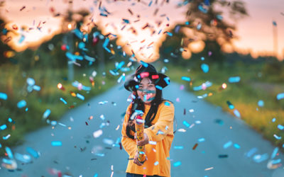 girl in yellow shirt shooting off confetti flying everywhere