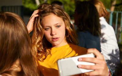 girl with serious face taking selfie