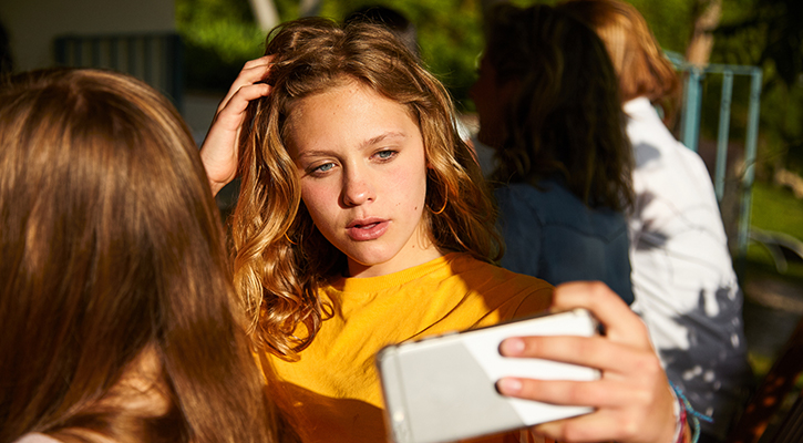 girl with serious face taking selfie