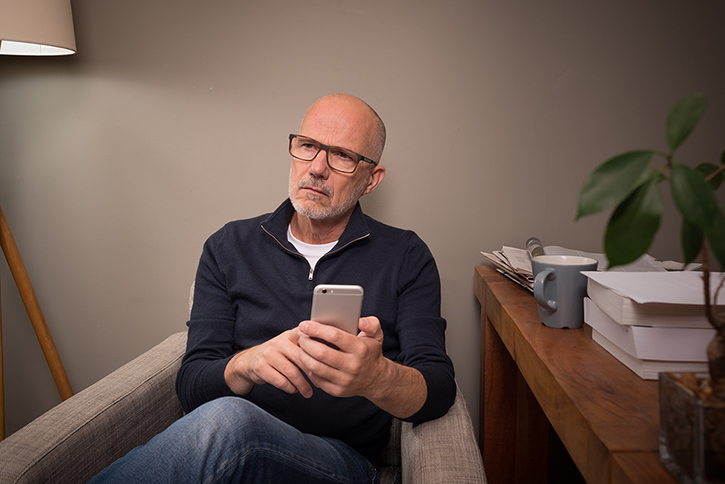 man pondering with a cell phone in hadn